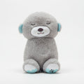 Gray teddy bear held by a hand with a blurred background