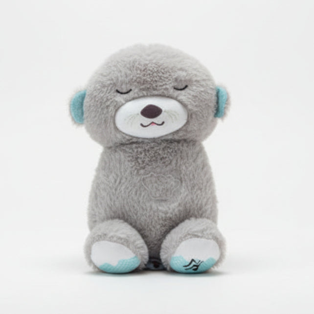 Gray teddy bear held by a hand with a blurred background