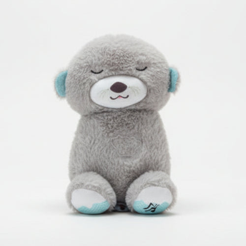 Gray teddy bear held by a hand with a blurred background